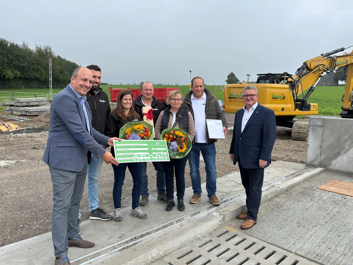 Links Marco Nuzzi (FDP), Stadtpräsident von Illnau-Effretikon, und rechts Bernard Hosang (FDP), Gemeindepräsident von Lindau, überreichen den Preis an das Team der Gebrüder Stocker Tiefbau AG. Sieben Menschen posieren für ein Foto einer Preisverleihung.